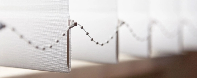 Lamellenabschlüsse mit Verbindungskette über einem Fensterbrett