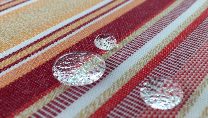 Rot gestreifter Markisenstoff mit Wasserperlen darauf